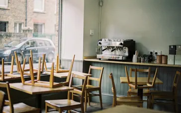 A small café after closing, with the lights off and chairs on the tables