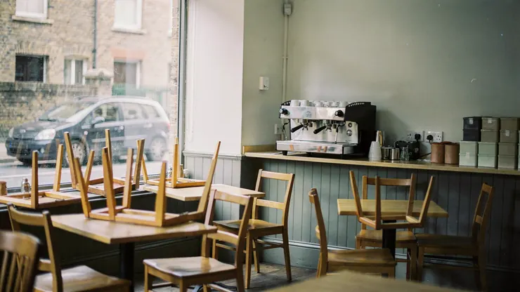 A small café after closing, with the lights off and chairs on the tables