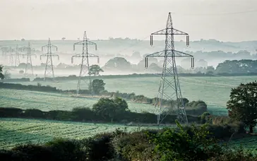 Electricity transmission pylons carrying high-voltage lines across farmland