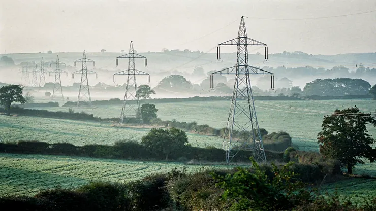 Electricity transmission pylons carrying high-voltage lines across farmland